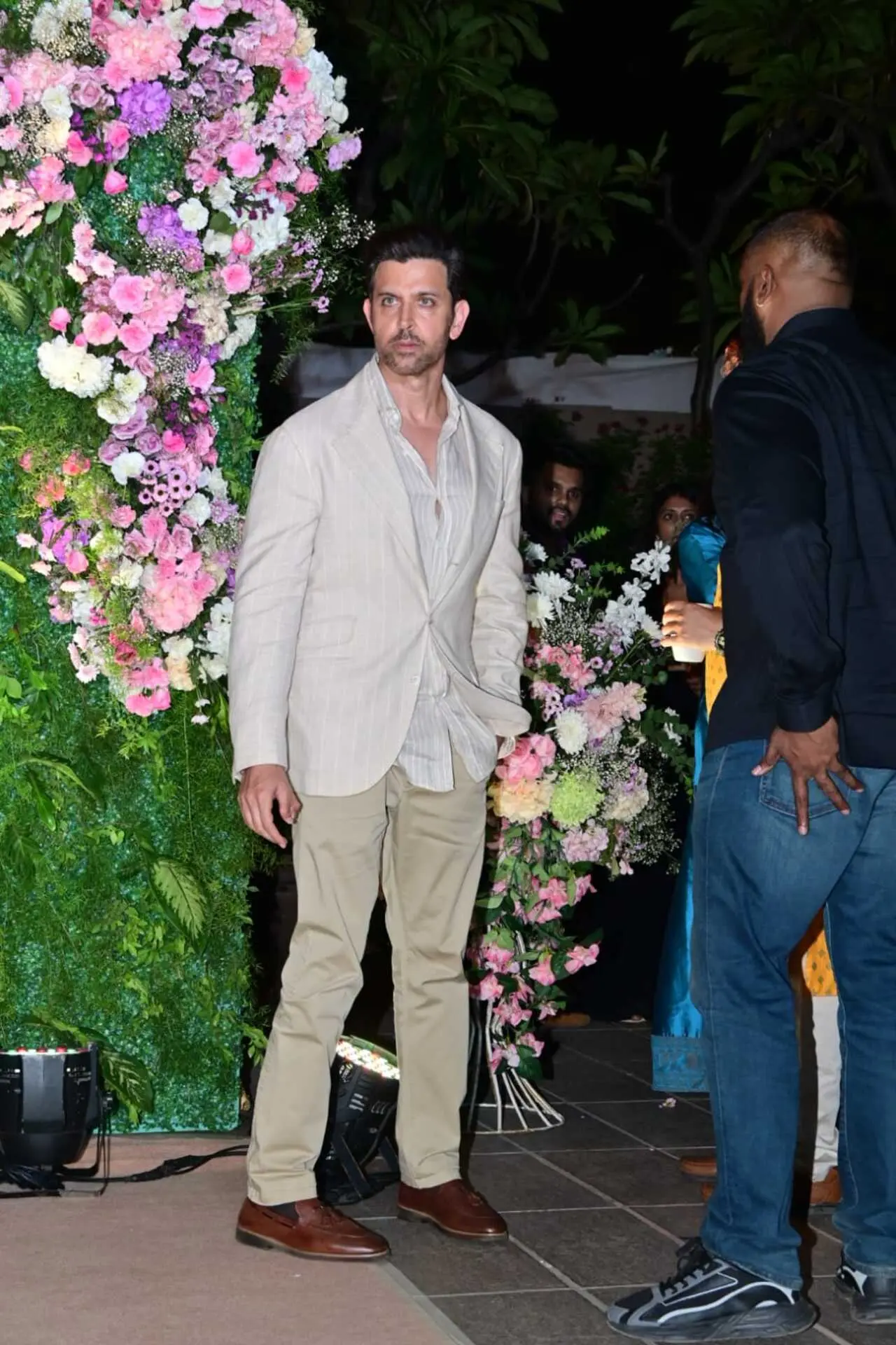 Hrithik Roshan was spotted arriving at a pre-wedding celebration in a sophisticated beige ensemble. The actor opted for a light beige blazer layered over a striped shirt, paired with matching trousers.